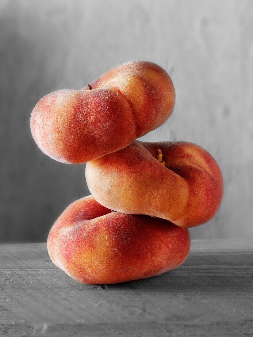Donut Peaches piled on top of each other against a black background