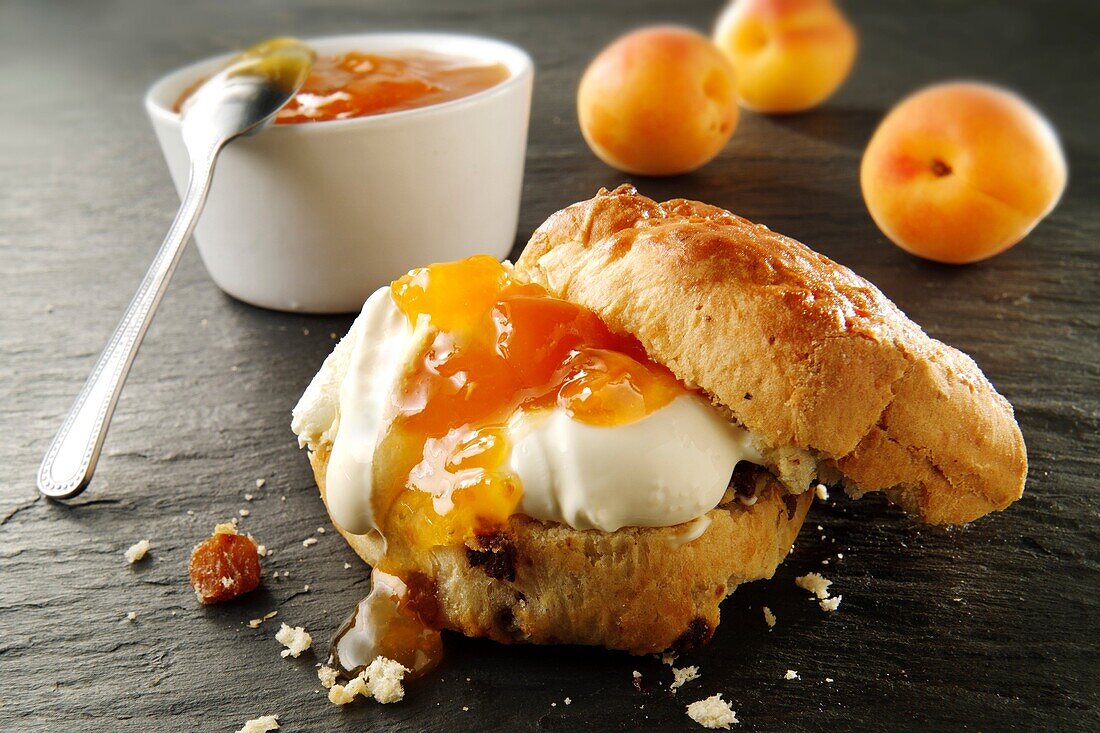 Traditional British scones with clotted cream and apricot jam