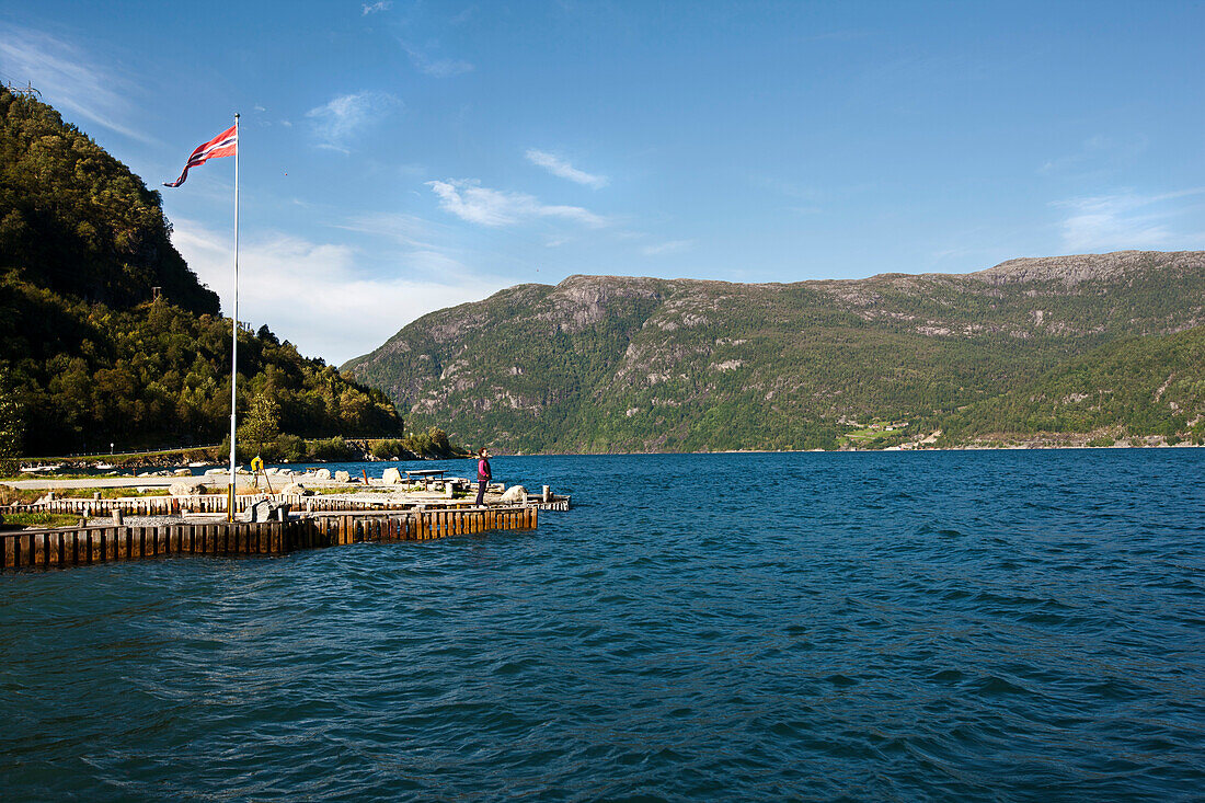 Campingplatz und Bootsanlegestelle nahe Odda, Frau schaut auf den Fjord, Folgefonn Nationalpark, Hordaland, Norwegen, Skandinavien, Europa