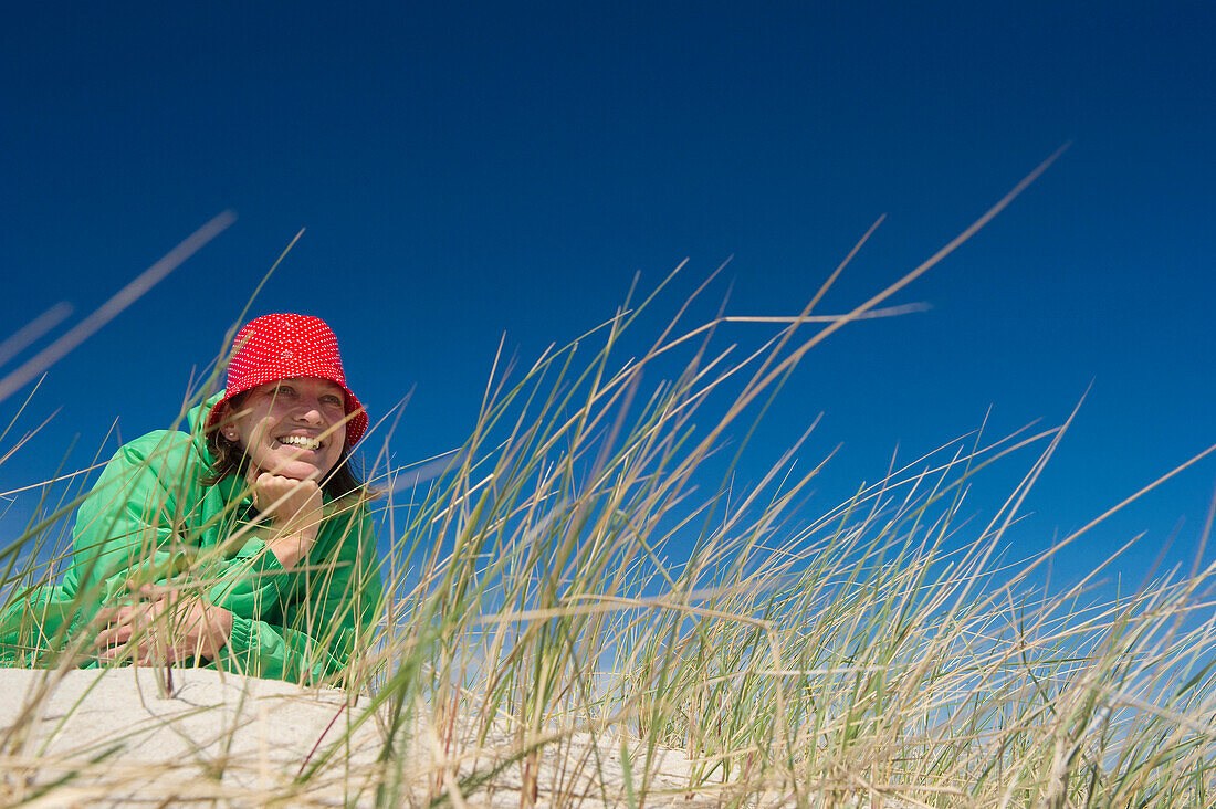 Frau liegt in einer Düne, Sylt, Schleswig-Holstein, Deutschland