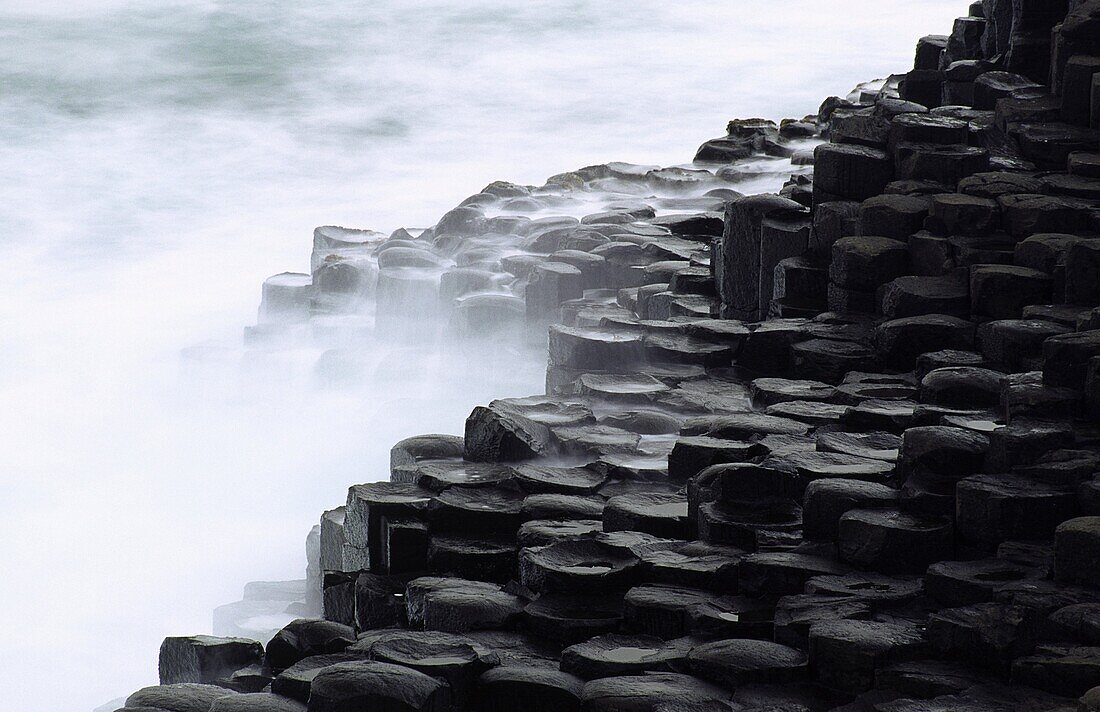 NORTHERN IRELAND, County Antrim, Giants Causeway Waves crash against the hexagonal basalts rock formations of this world heritage site