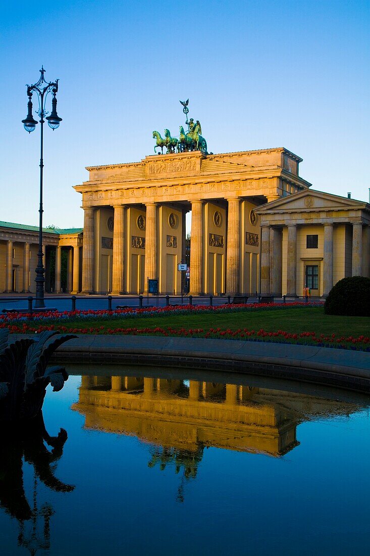 Reflection of the Brandenburg Gate Berlin Germany In Fountain Water bathed in a golden light The Brandenburg Gate German: Brandenburger Tor is a former city gate and one of the main symbols of Berlin and Germany