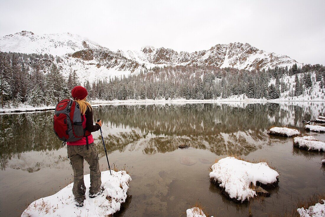 Hiker enjoying the view of Sawtooth montains with the reflection in Phyllis lake, Idaho