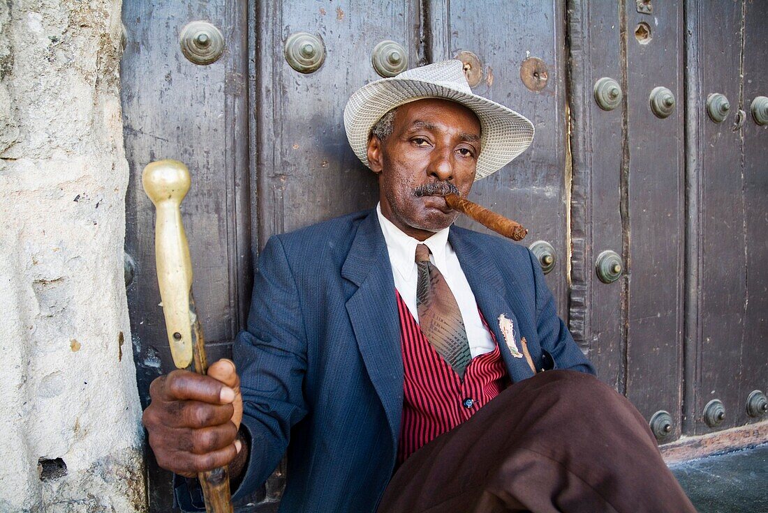 Man wearing a 1930 s fashion style suit simulating the smoking of a cigar, Havana Cuba