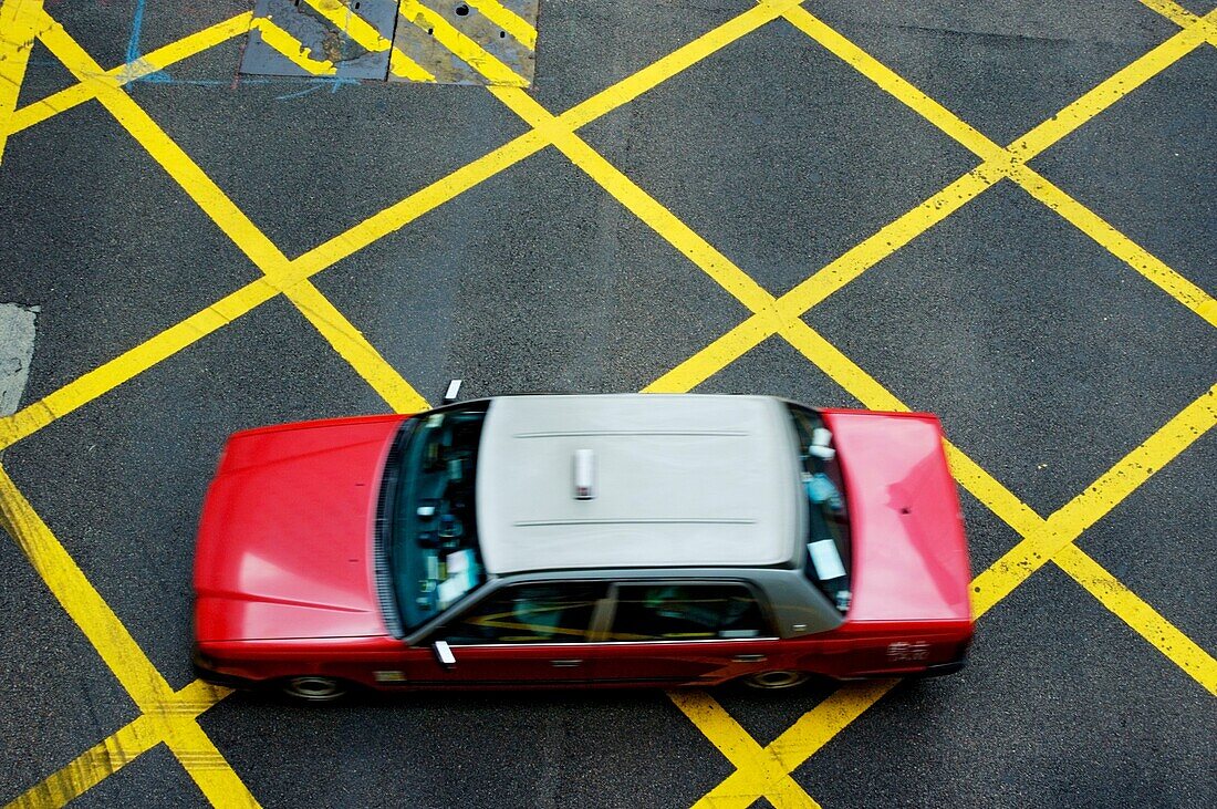 China hong kong island a red taxi cab driving on yellow lines