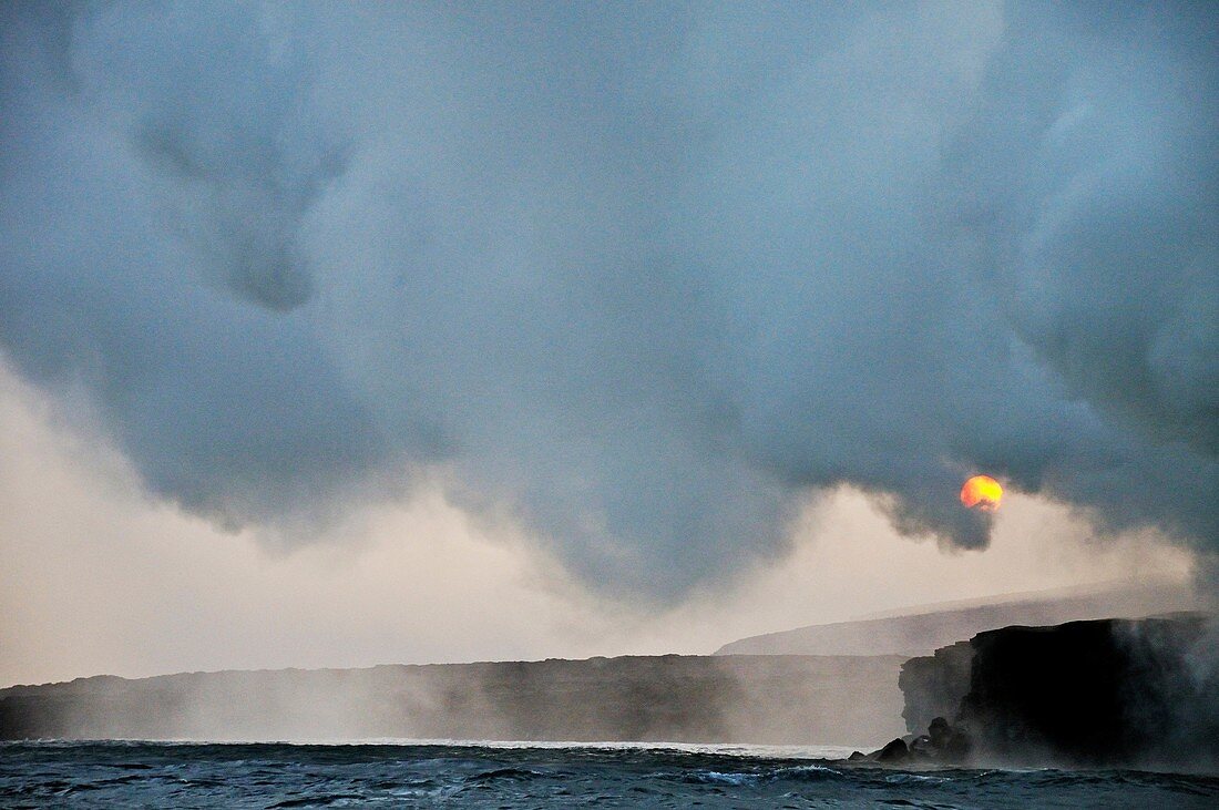 Steam rising off lava flowing into ocean at sunset, Kilauea Volcano, Hawaii Islands, United States