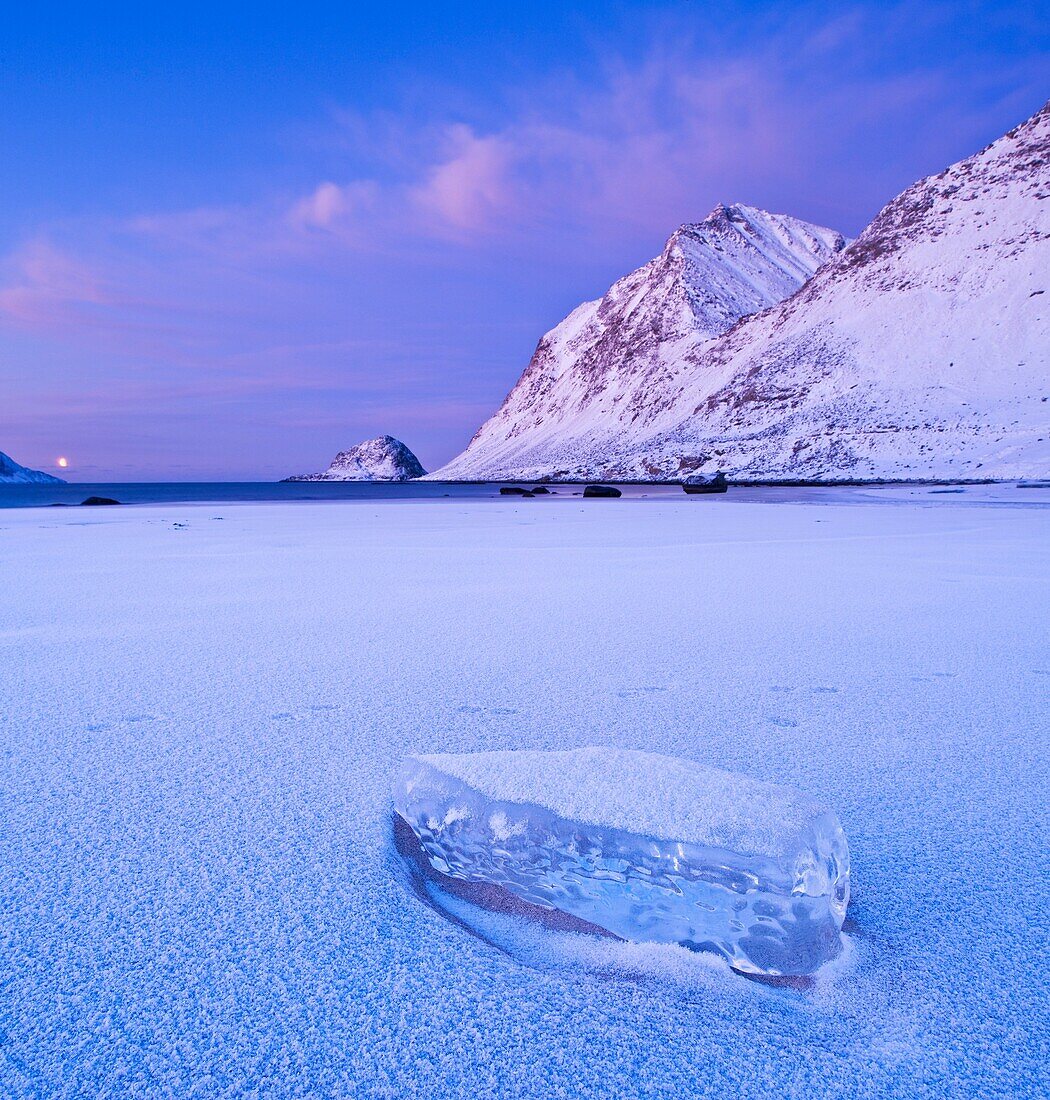 Block of ice on frozen Haukland beach in winter, Vestvagøy, Lofoten islands, Norway