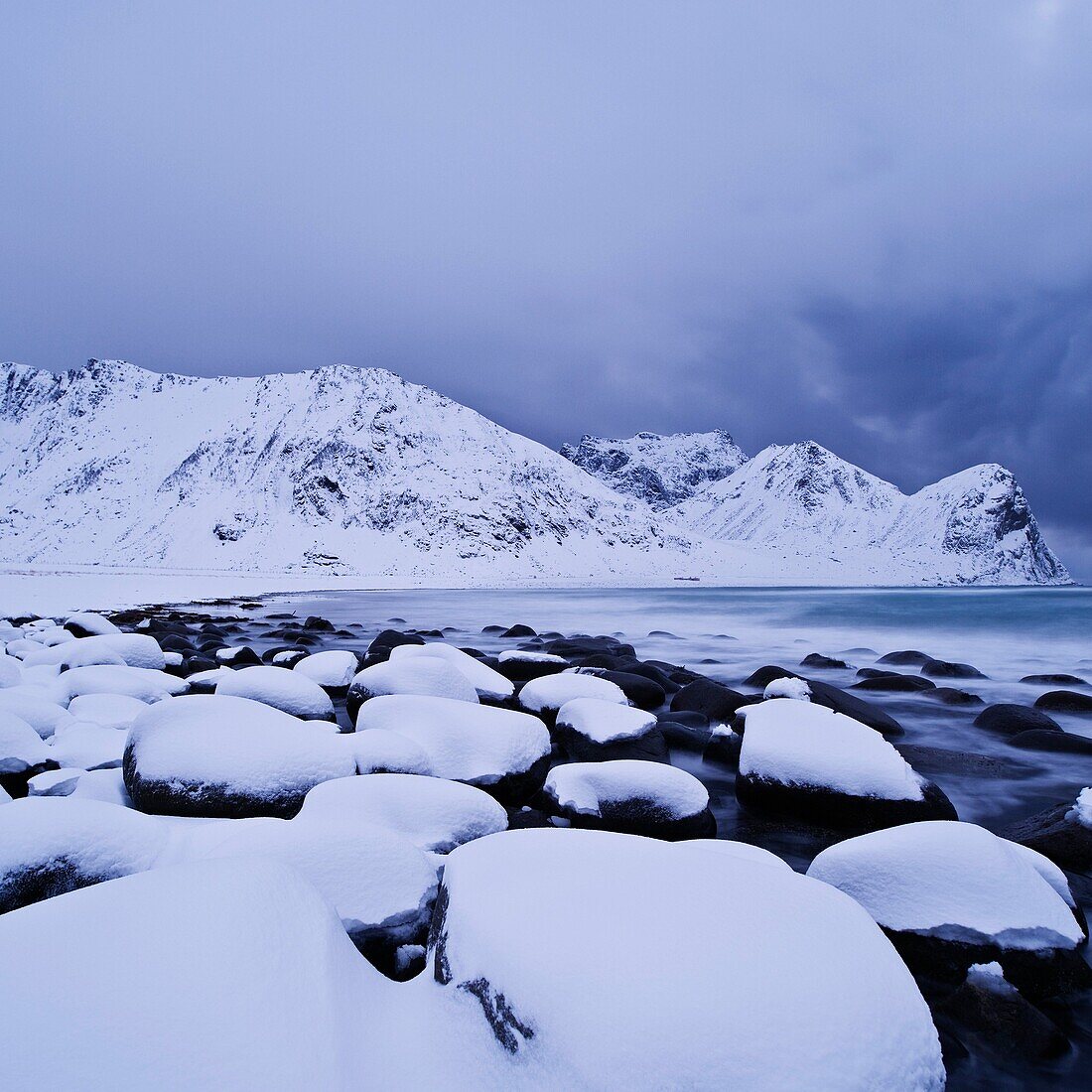 Snow covered rocks at Unstad beach, Vestvågøy, Lofoten islands, Norway