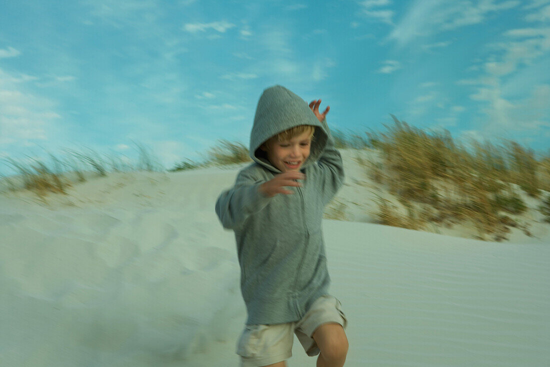 Boy running down dune