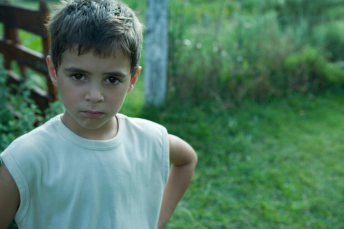 Boy standing outdoors, looking at camera, portrait