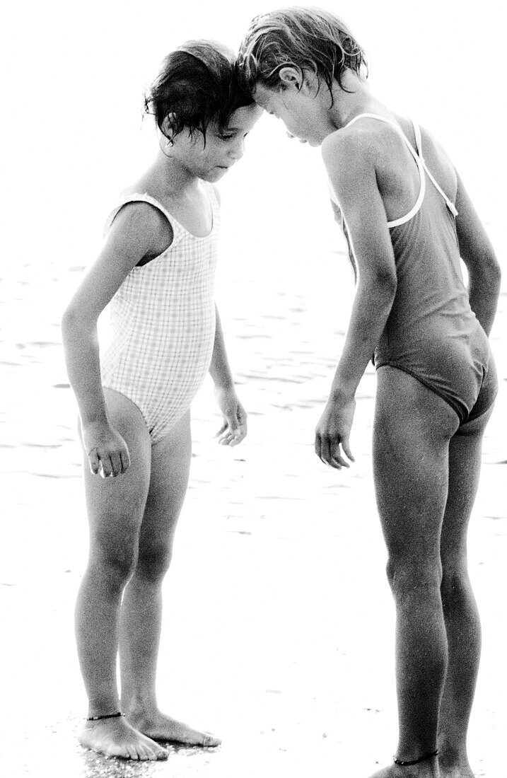 Two girls in bathing suits touching foreheads