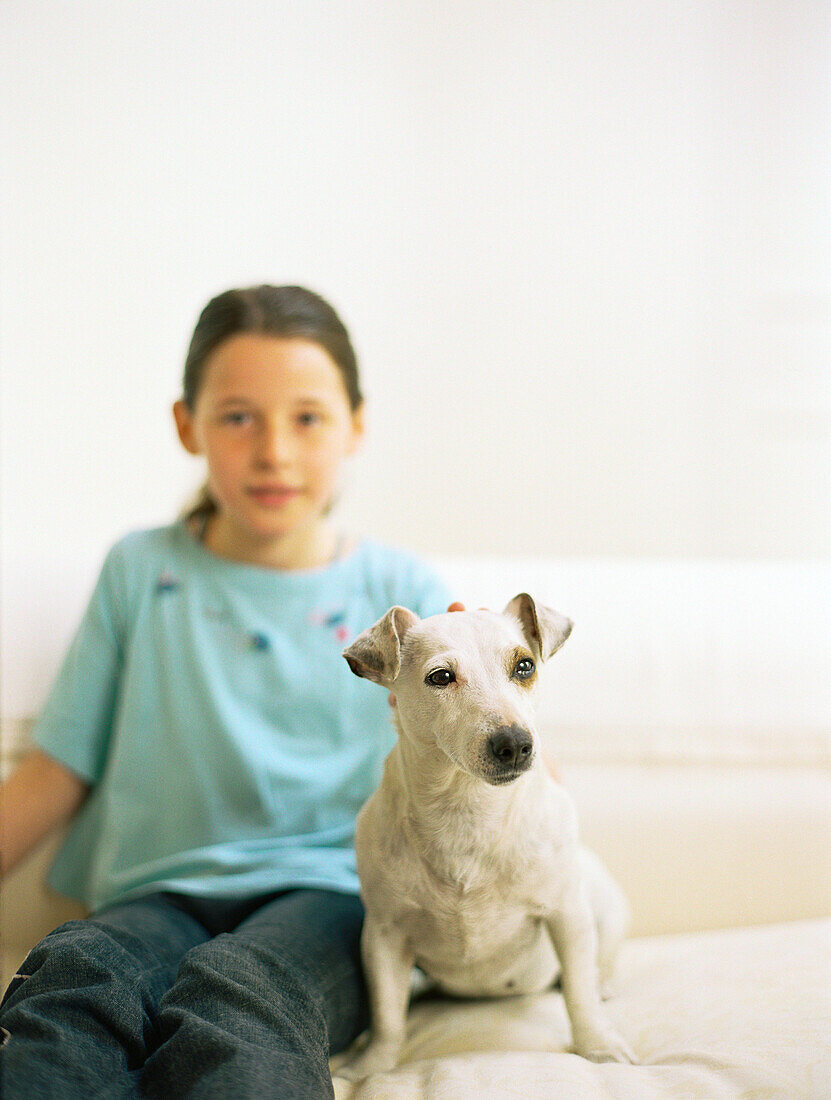 Girl sitting on sofa with dog