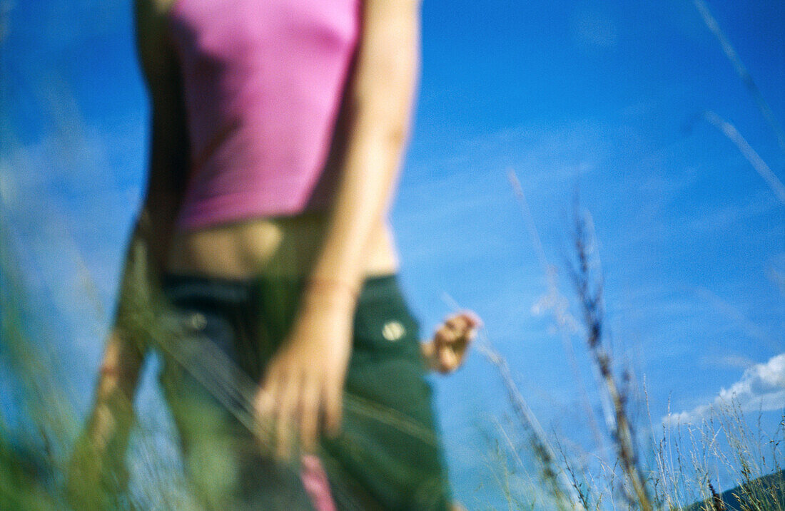 Mädchen steht im hohen Gras