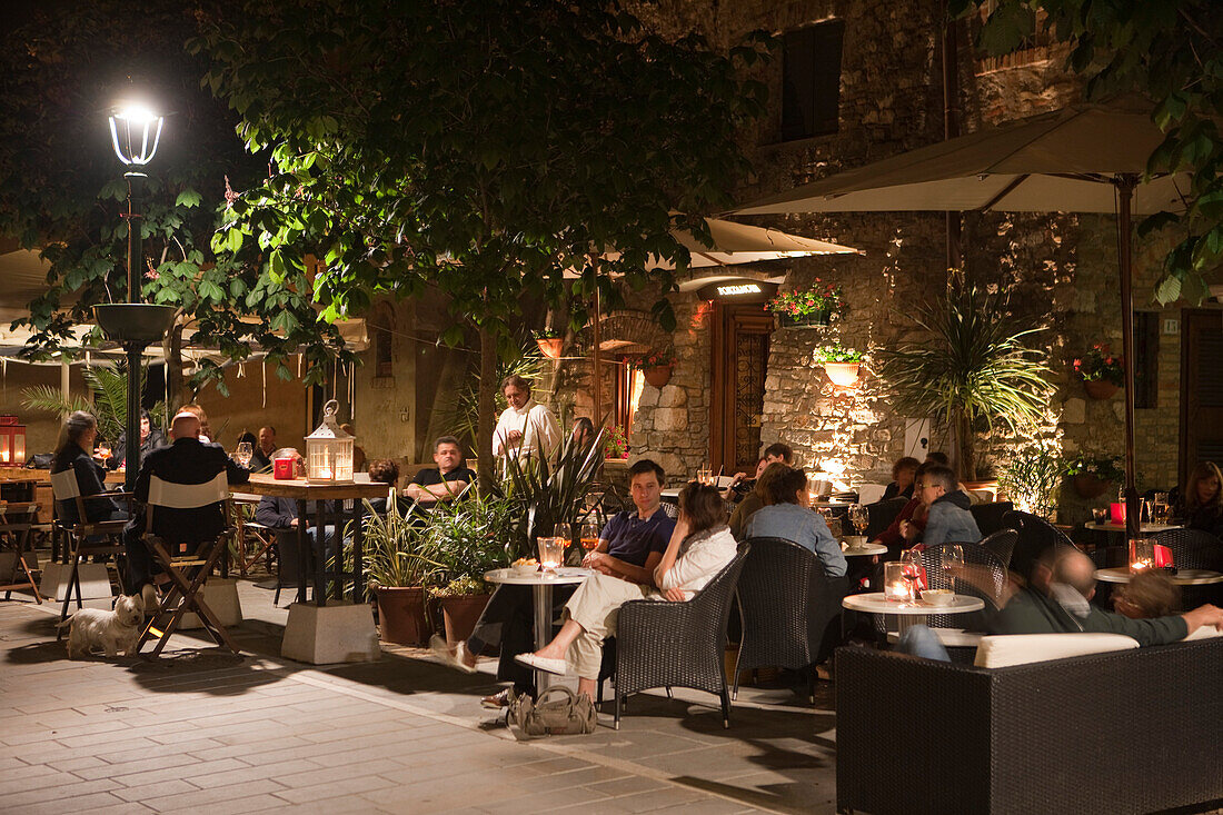 People enjoying a drink at an outdoor bar at night, Grado, Friuli-Venezia Giulia, Italy