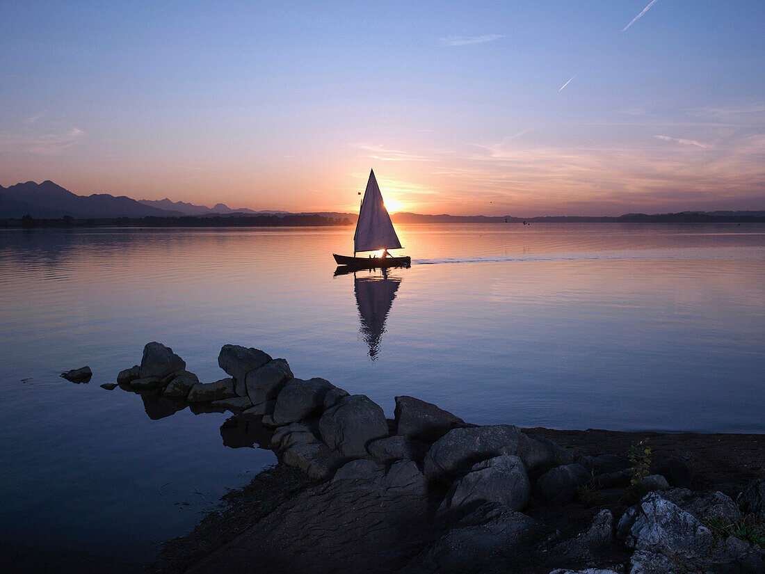 Sailboat on lake Chiemsee in sunset, Chiemgau, Bavaria, Germany