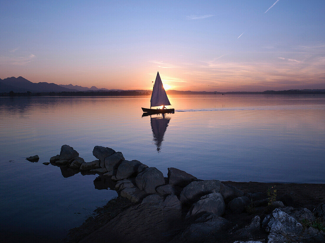 Segelboot auf dem Chiemsee im Sonnenuntergang, Chiemgau, Bayern, Deutschland