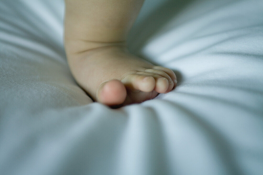 Baby standing, cropped view of one foot, close-up