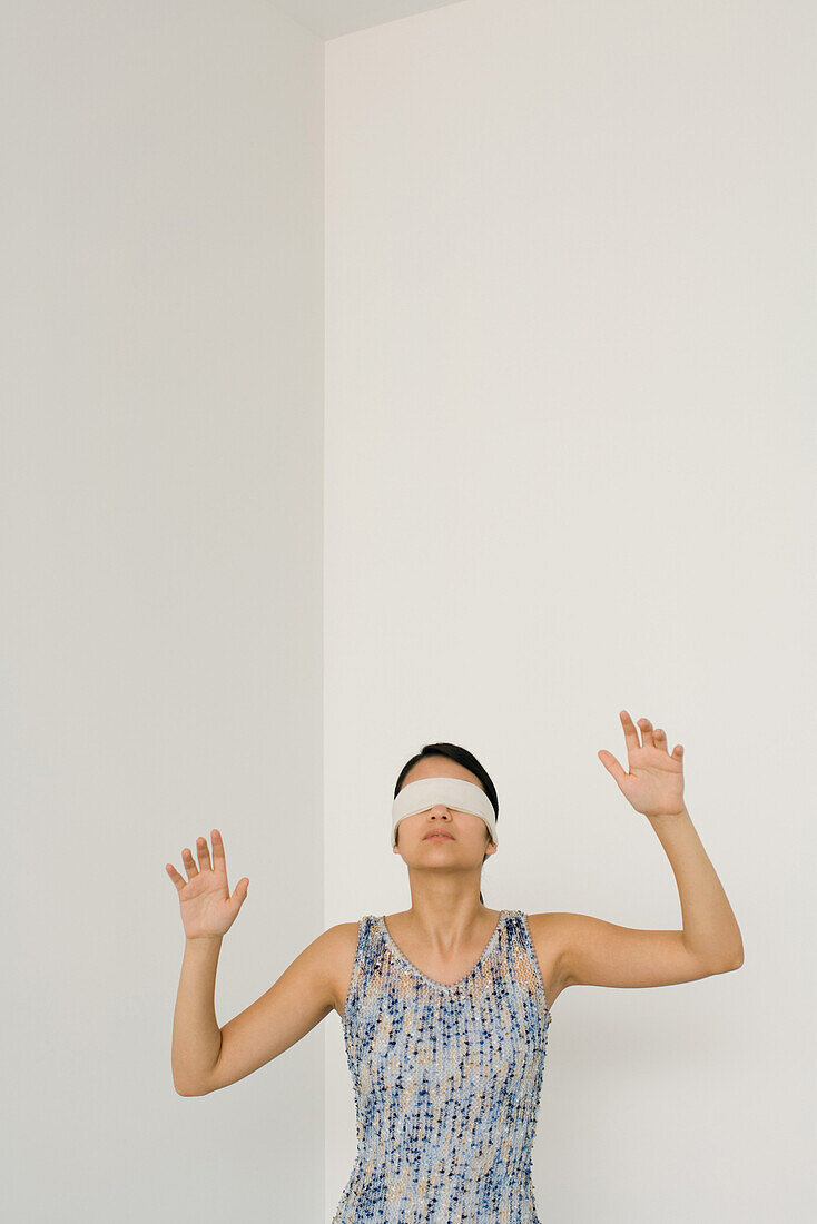 Woman blindfolded, hands raised