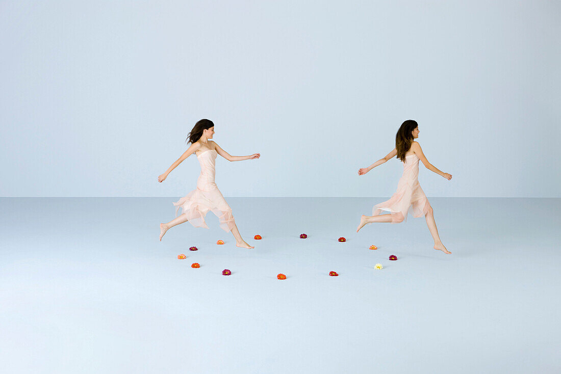 Young women running across circle of flowers