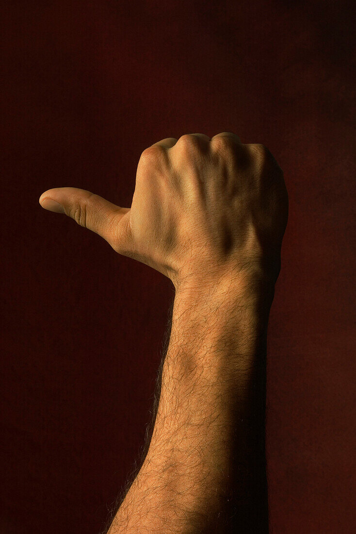 Hand raised, thumb extended