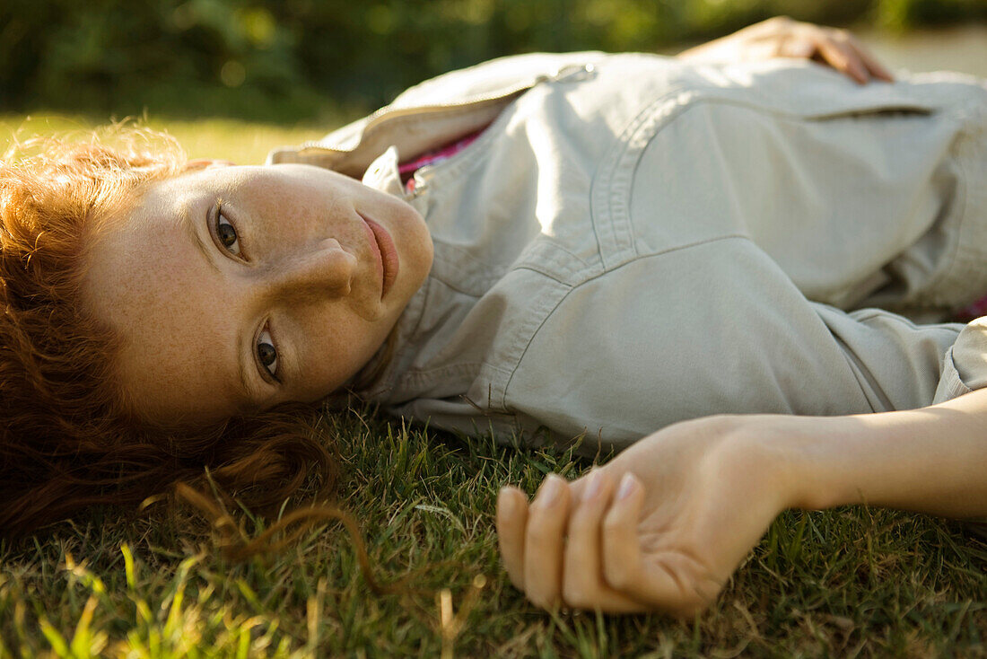 Junge Frau auf dem Rücken im Gras liegend