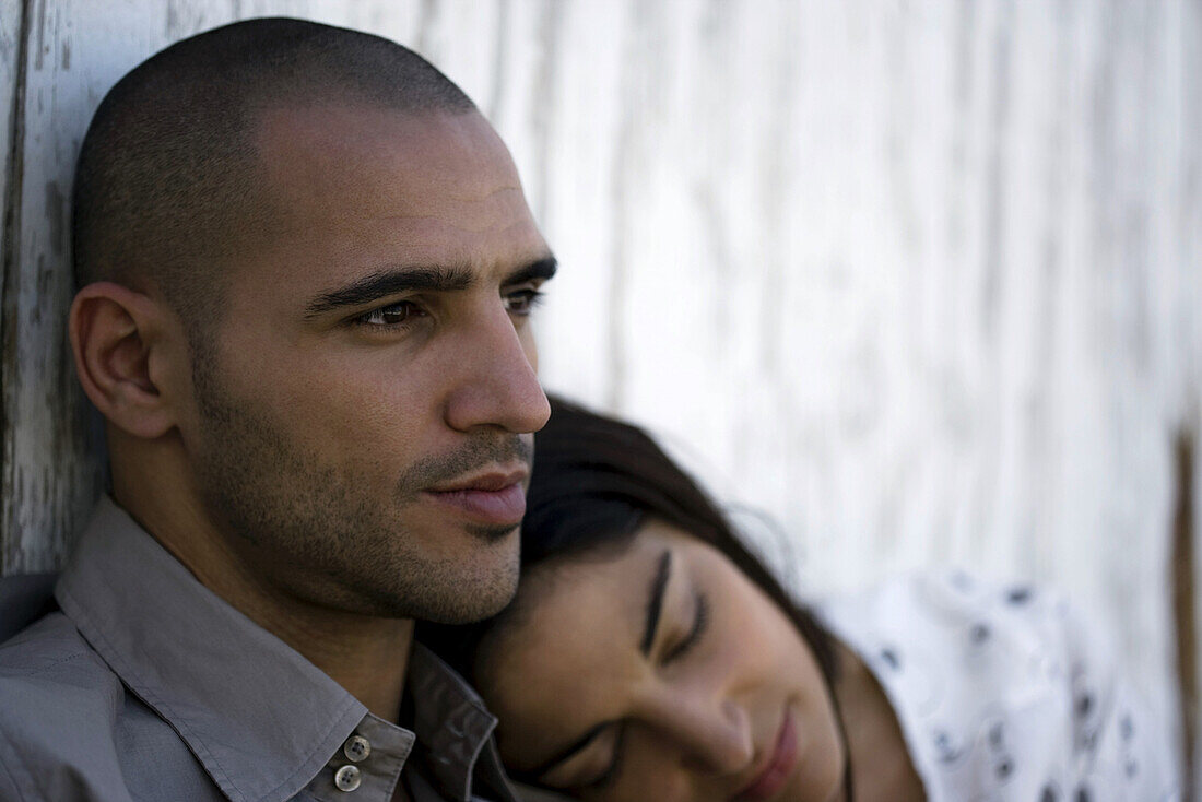 Young woman resting head on man's shoulder
