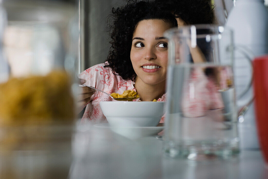 Young woman daydreaming at breakfast table