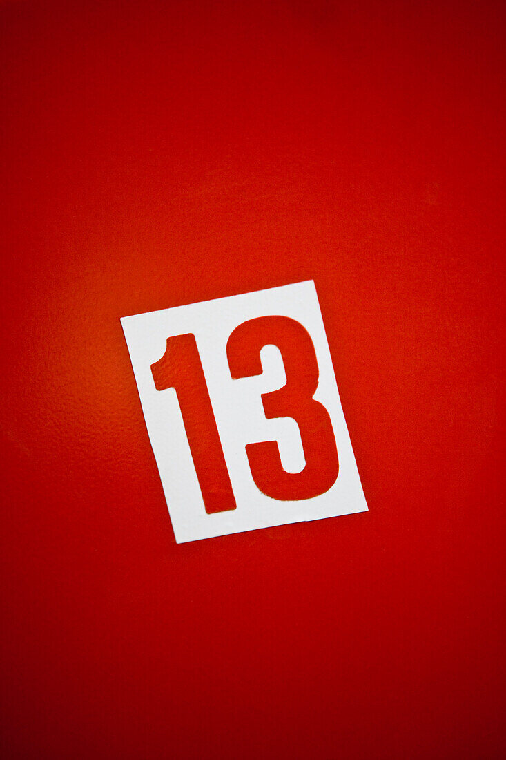Number thirteen against red background