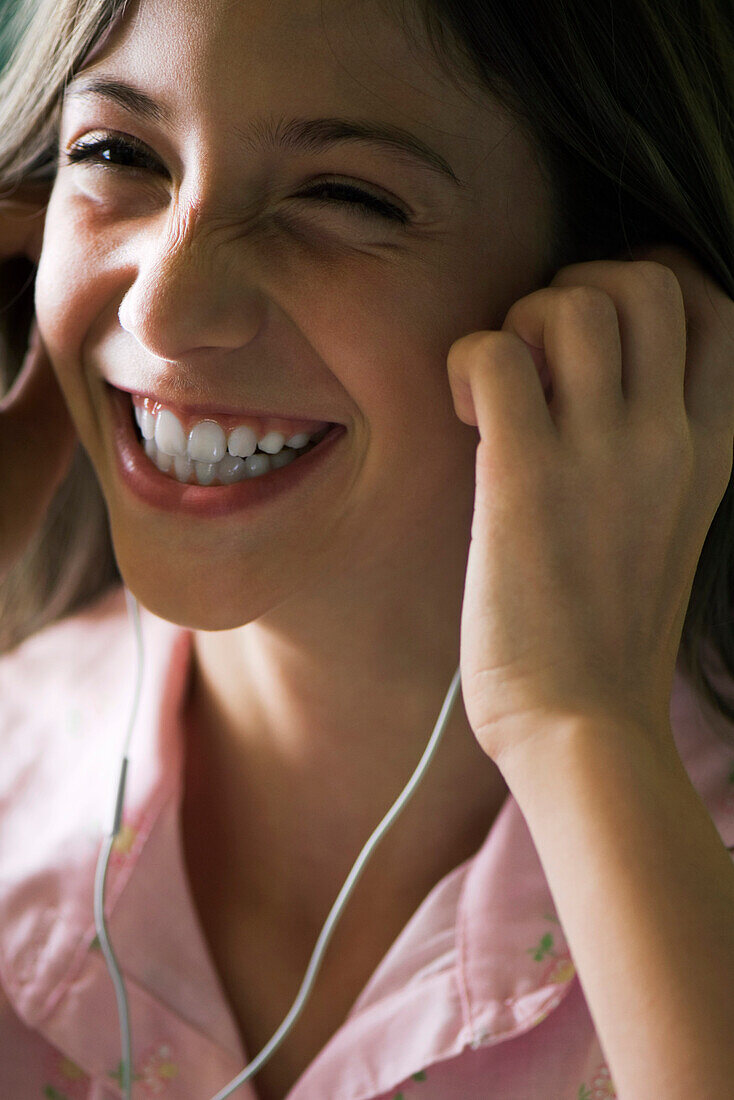 Female listening to music with earphones, smiling