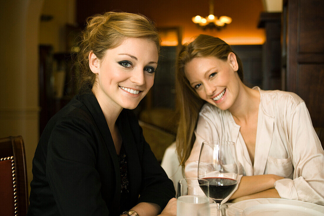 Woman having glass of wine with friend in restaurant