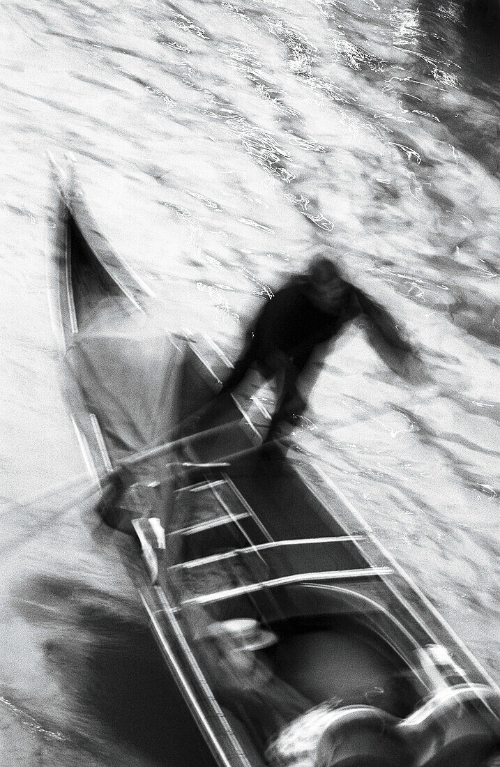 Person rowing gondola, high angle view, b&w