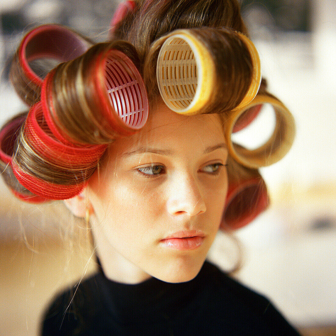 Junge Frau mit Lockenwicklern im Haar