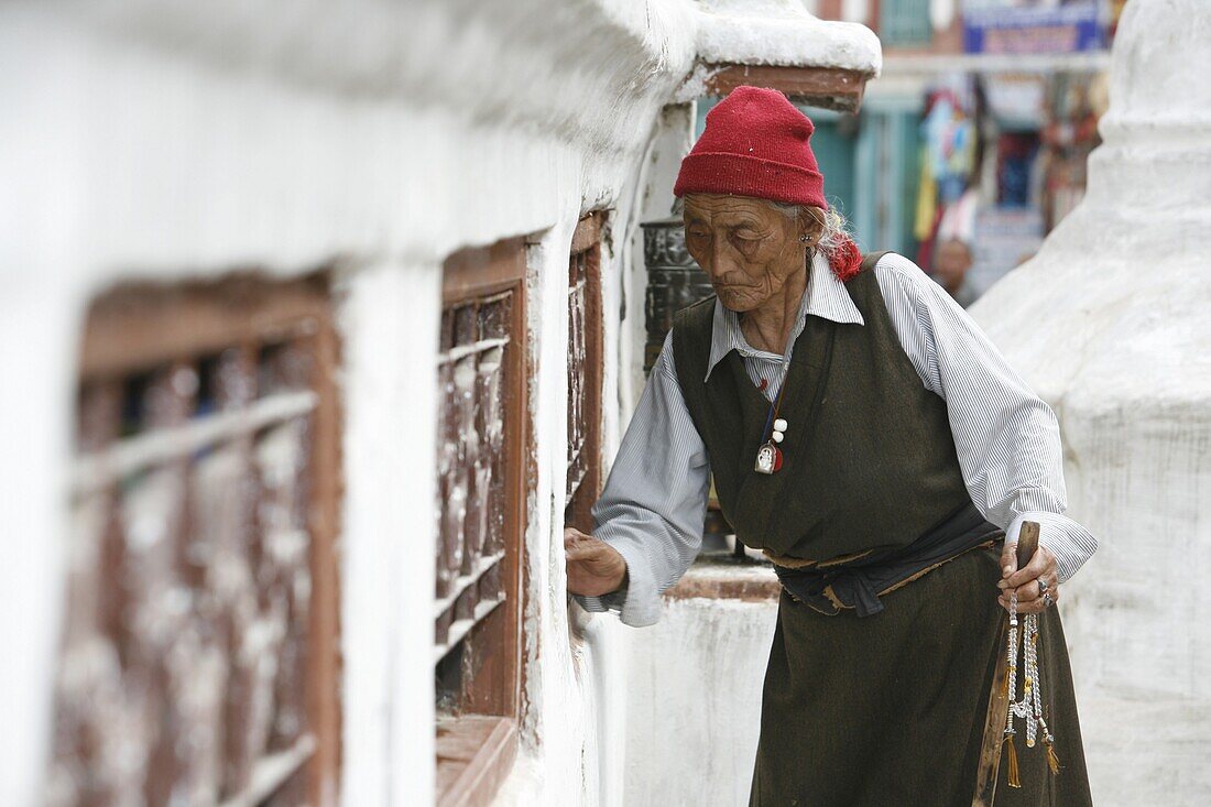 Népal, Kathmandu, Woman and prayer wheels. Baudhnath Stupa.