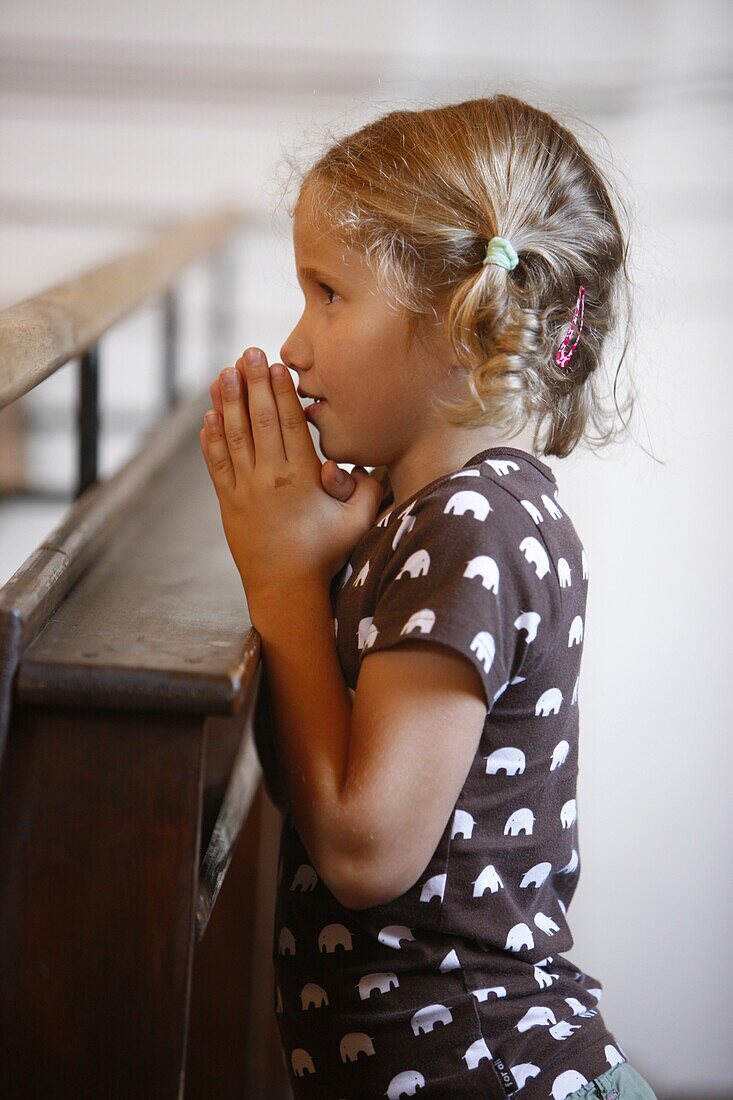 France, Saint Nicolas de Veroce, Girl praying in Saint-Nicolas de Véroce church