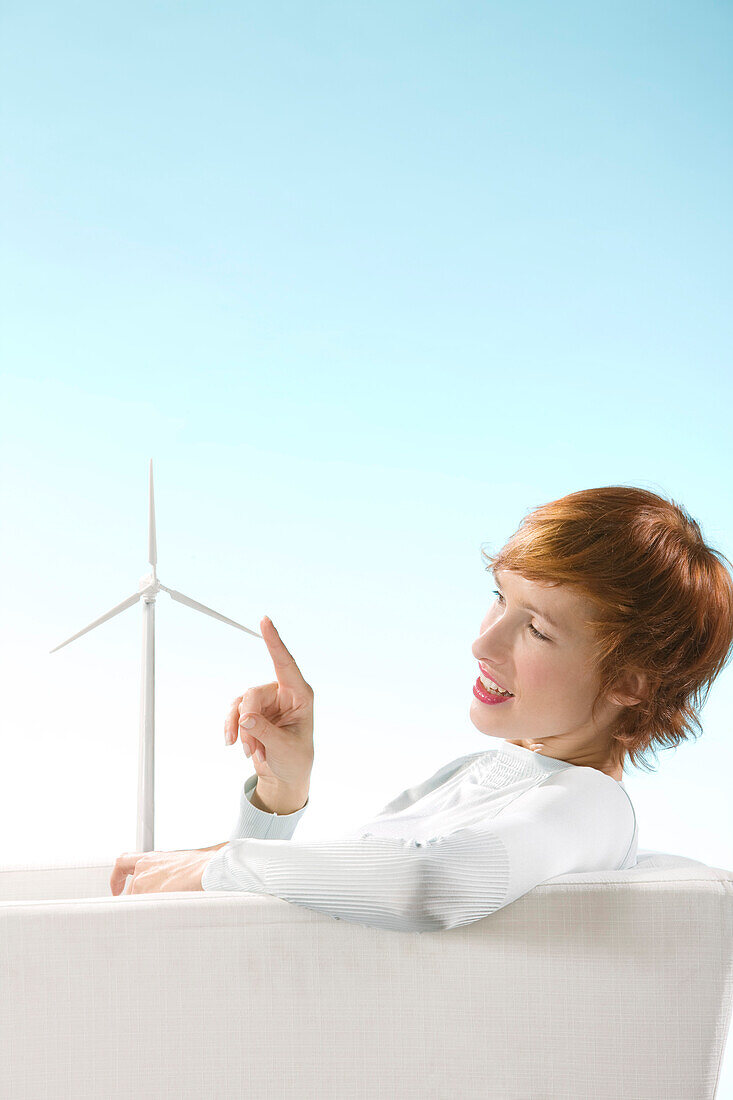 Claire playing with a wind turbine in her hand in a clear blue background