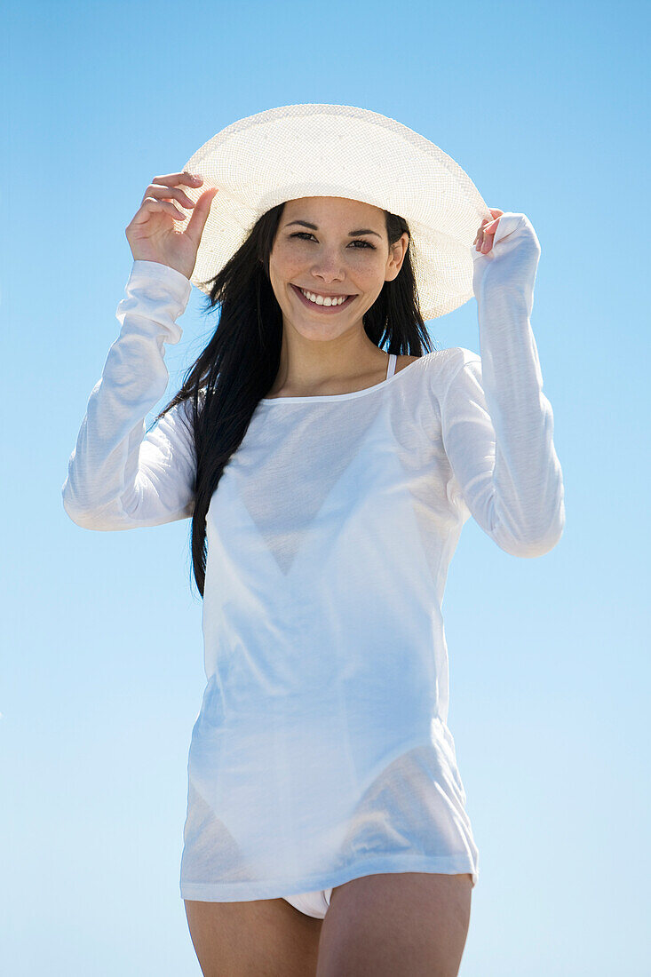 Young woman smiling for camera, white hat
