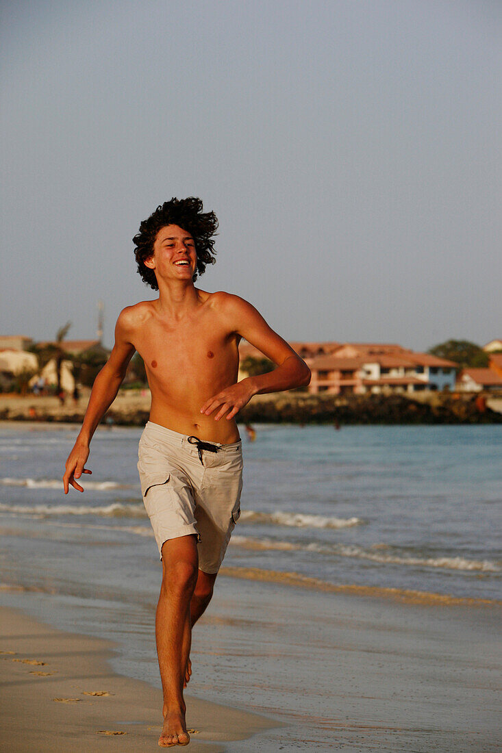 Cape Verde Peninsula, Sal, Santa Maria beach, teenage boy running on the beach