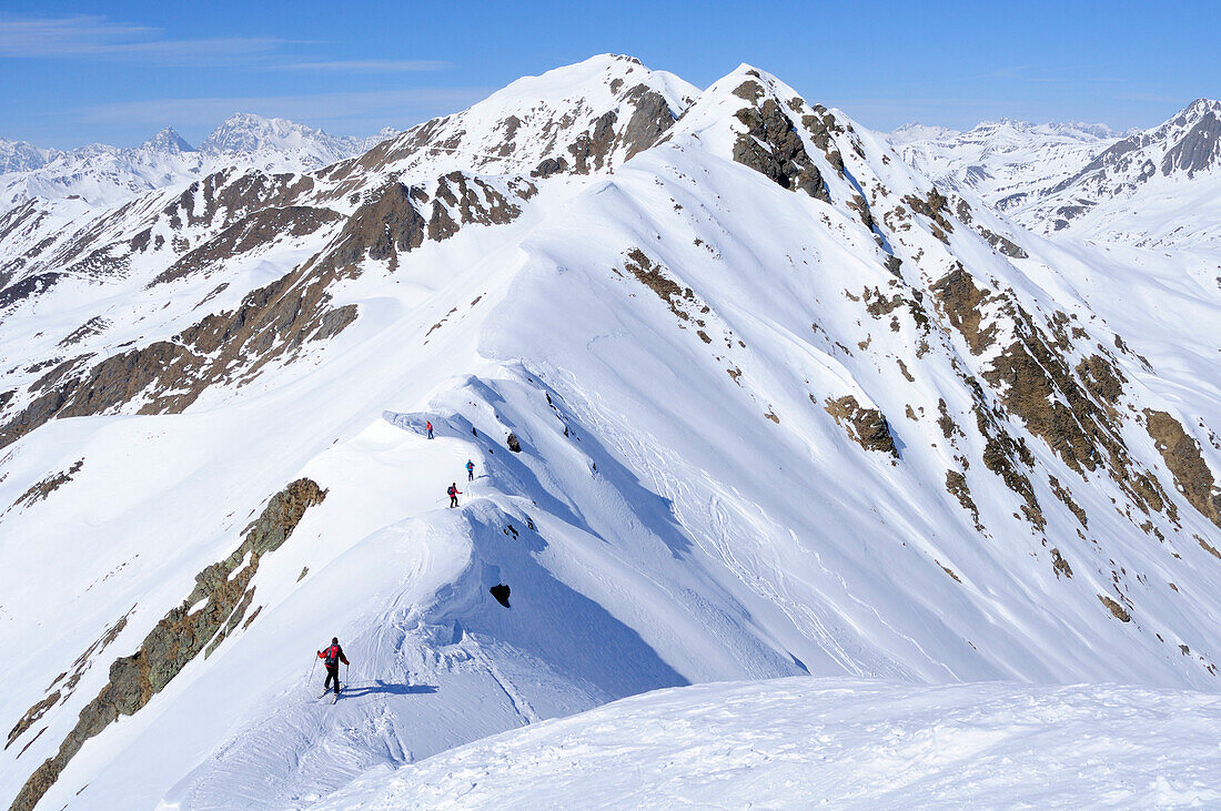 Group of people backcountry skiing, going down a ridge, Villgraten range in background, Kreuzspitze, Villgraten range, Hohe Tauern range, East Tyrol, Austria, Europe