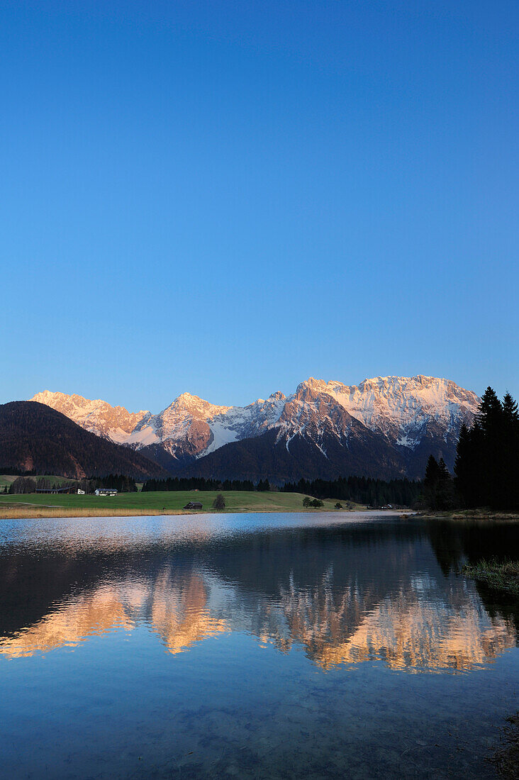 Verschneite Karwendelkette spiegelt sich in einem Bergsee, Krün, Werdenfelser Land, Bayerische Alpen, Oberbayern, Bayern, Deutschland