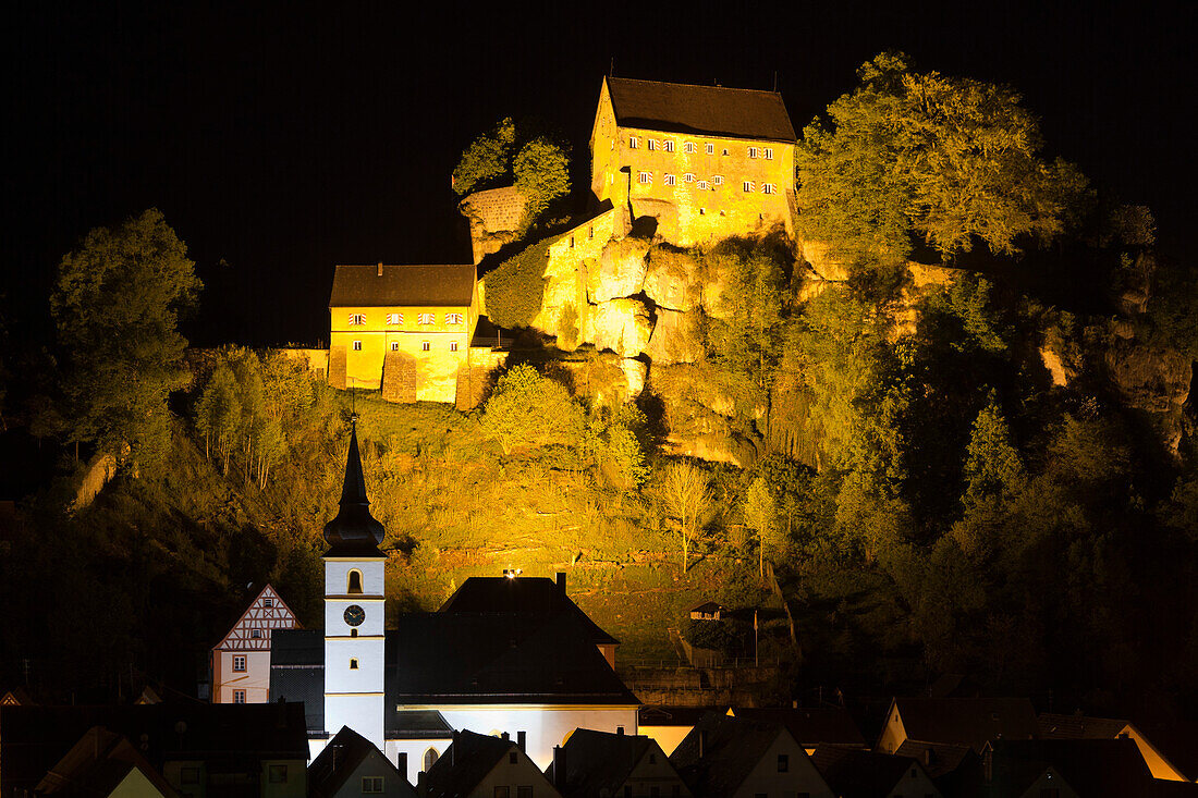 View over the town onto the illuminated castle at night, Pottenstein, Fraenkische Schweiz, Franconia, Bavaria, Germany, Europe