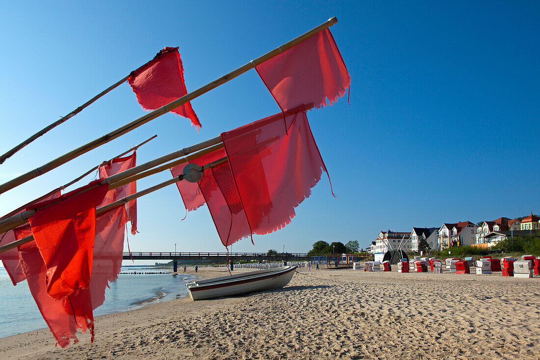 Fishing boat and red flags on the beach, Bansin seaside resort, Usedom island, Baltic Sea, Mecklenburg-West Pomerania, Germany