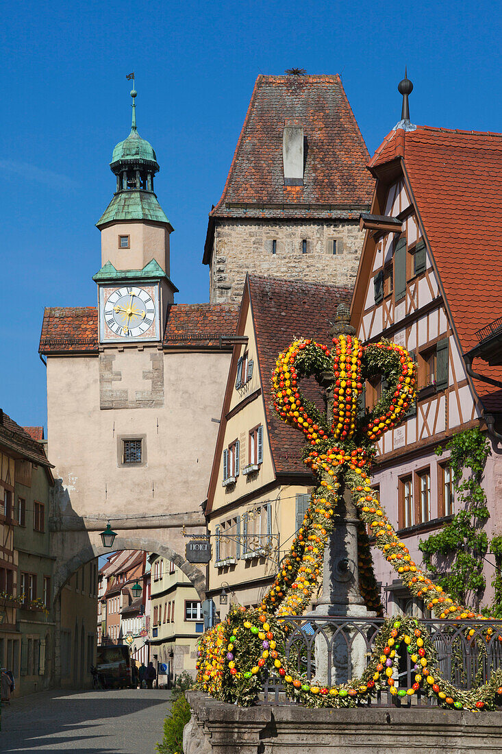 Fountain decorated with Easter eggs, Markus Tower with the Röder Arch, Rothenburg ob der Tauber, Franconia, Bavaria, Germany