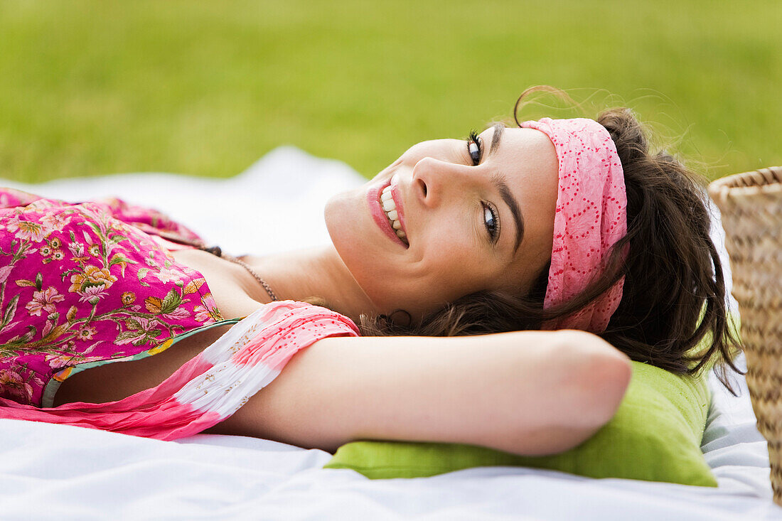 Young woman smiling, lying, oudoors