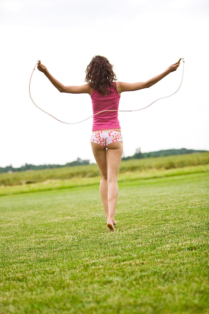 Young woman usig a skipping rope, oudoors