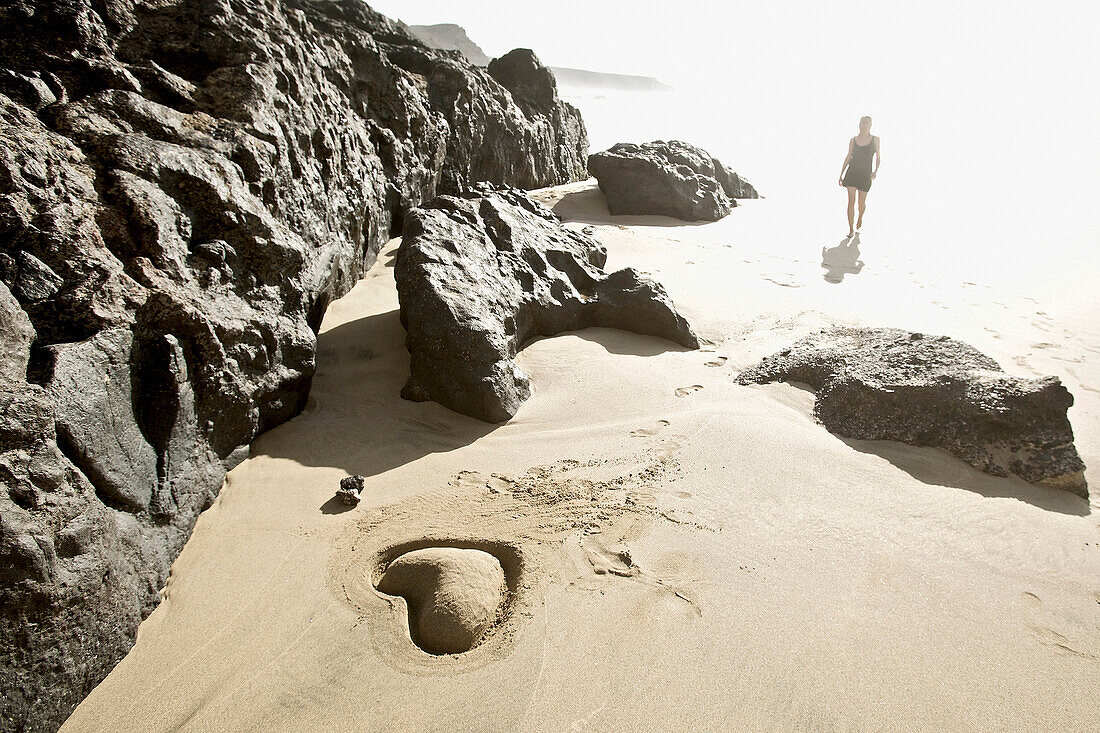 Junge Frau am Strand, Sandherz im Vordergrund, Fuerteventura, Spanien