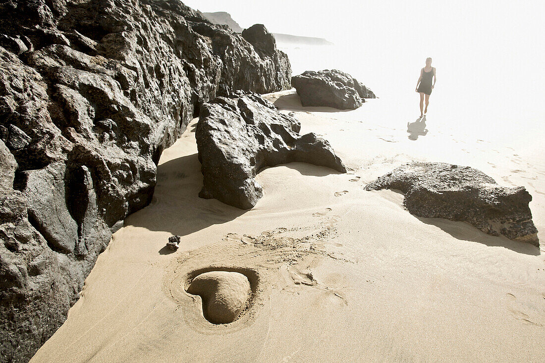 Young woman at beach near heart shaped, Fuerteventura, Spain