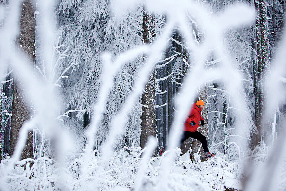 Man jogging through winter scenery, Irsee, Bavaria, Germany