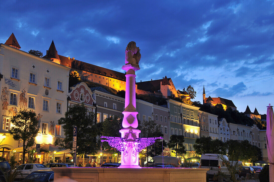 Blick auf beleuchteten Brunnen am Stadtplatz mit Burg, Burghausen, Bayern, Deutschland, Europa