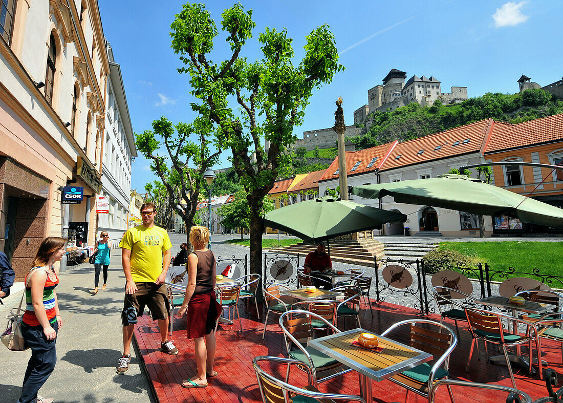 Street cafe at Mierove square with castle, Trencin, western Slovakia, Europe