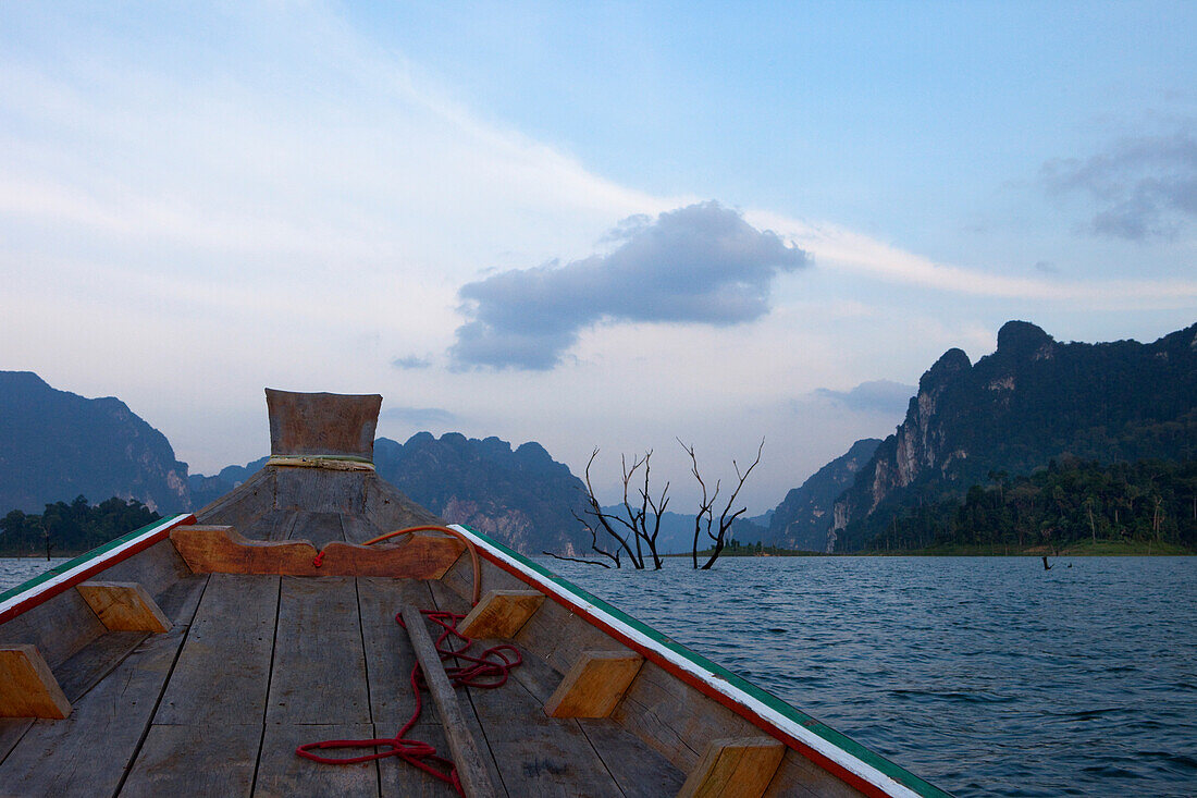 Longtailboot und Karstfelsen am Abend auf dem Stausee des Khao Sok Nationalparks, Khao Sok Nationalpark, Andamanensee, Thailand